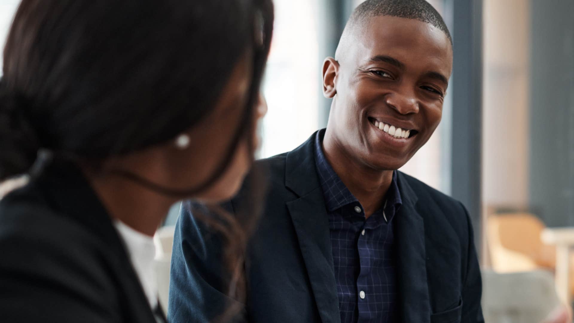 self-assured man happily talking to a co-worker