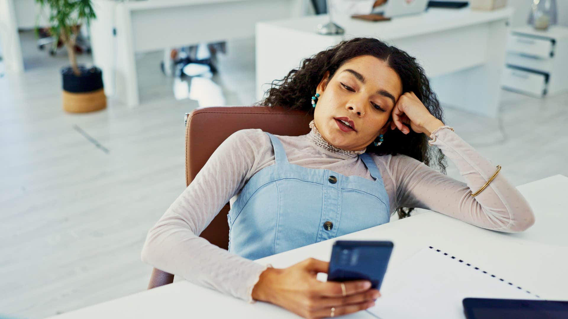 Unmotivated person scrolls at work showing wrong career