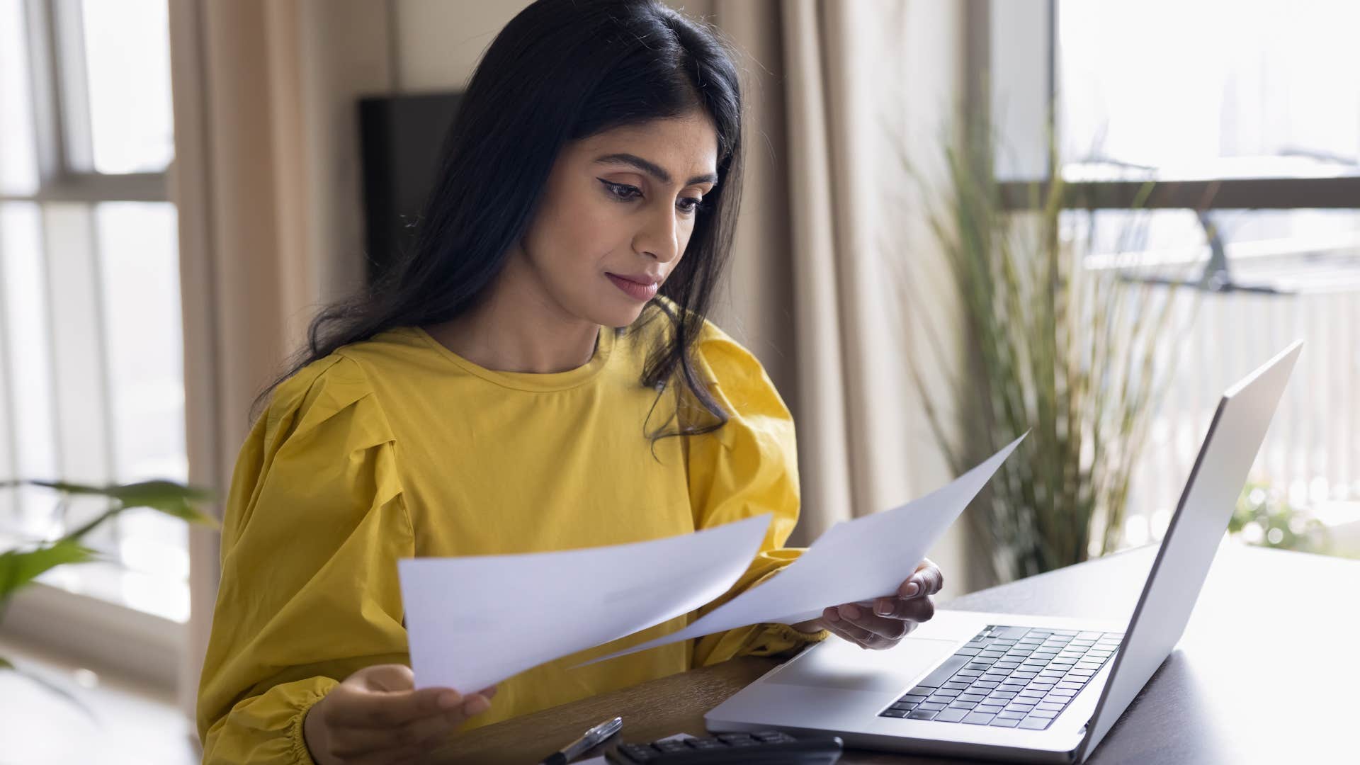 Realist woman doing bills at home.
