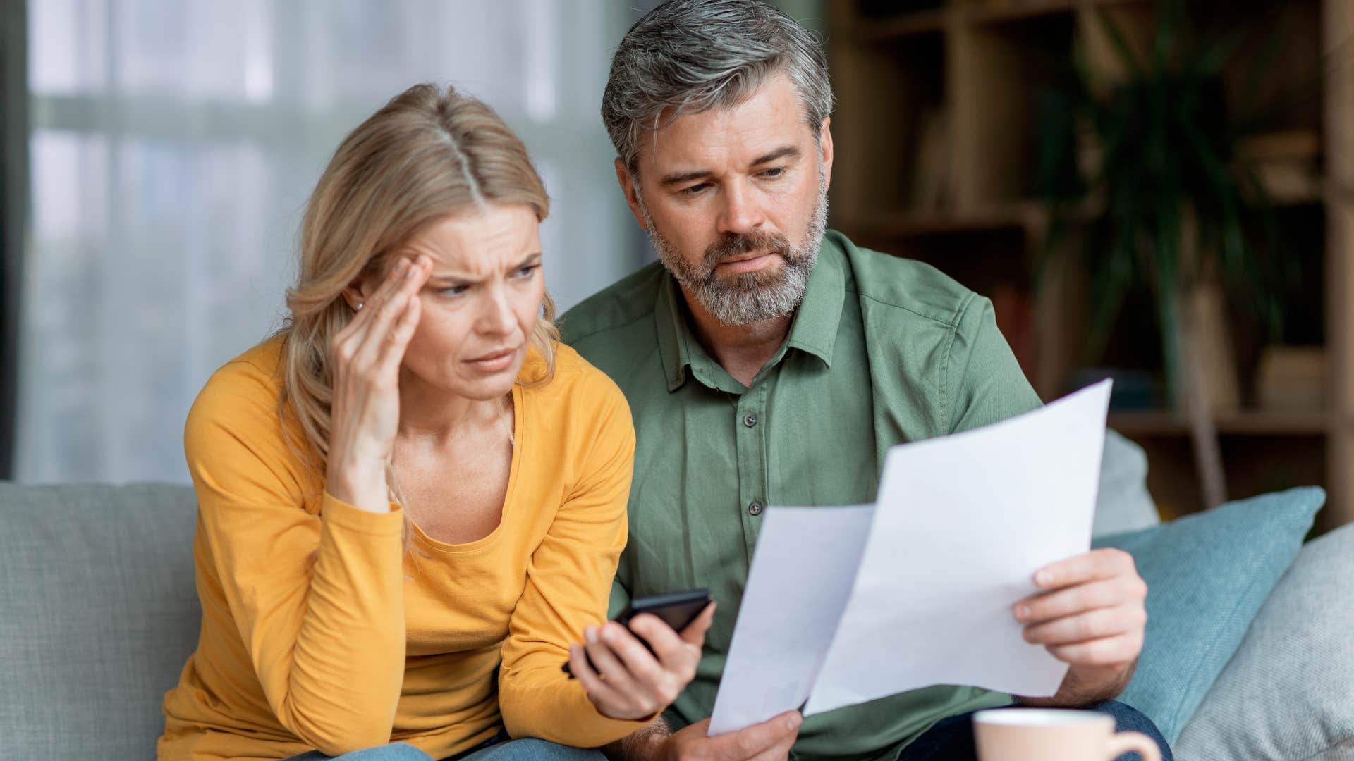 Couple who's frugal and cautious with spending doing bills.