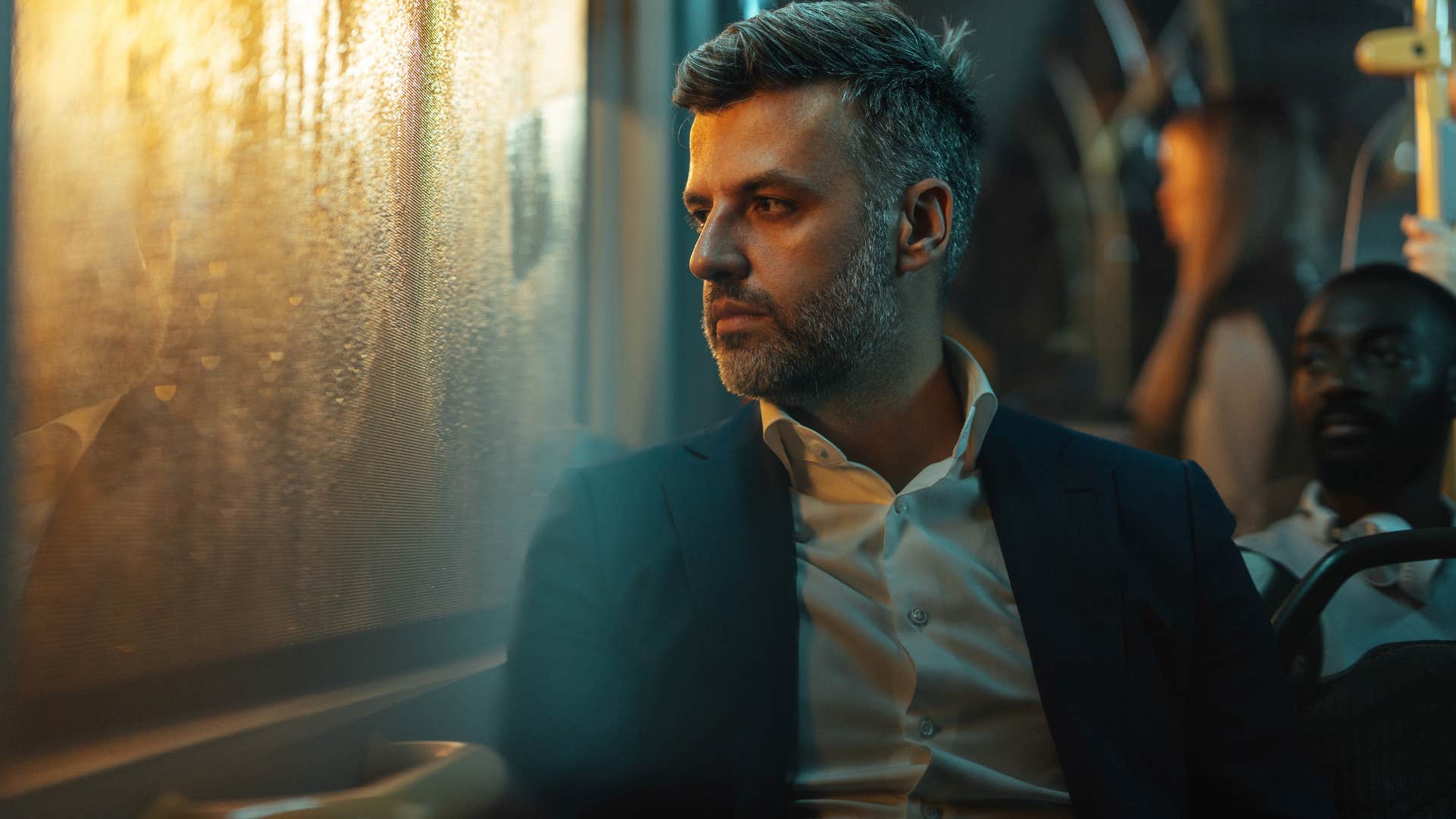 Observant man looking out the window of a bus.