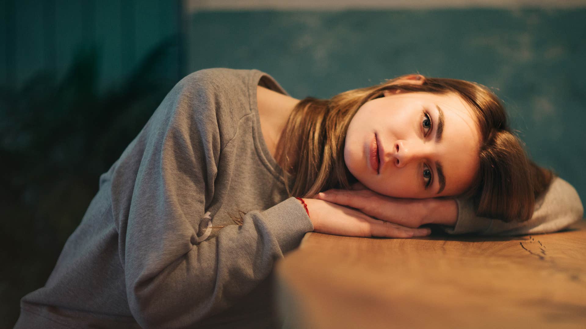 Anxious person lays head on table showing emotional stage 