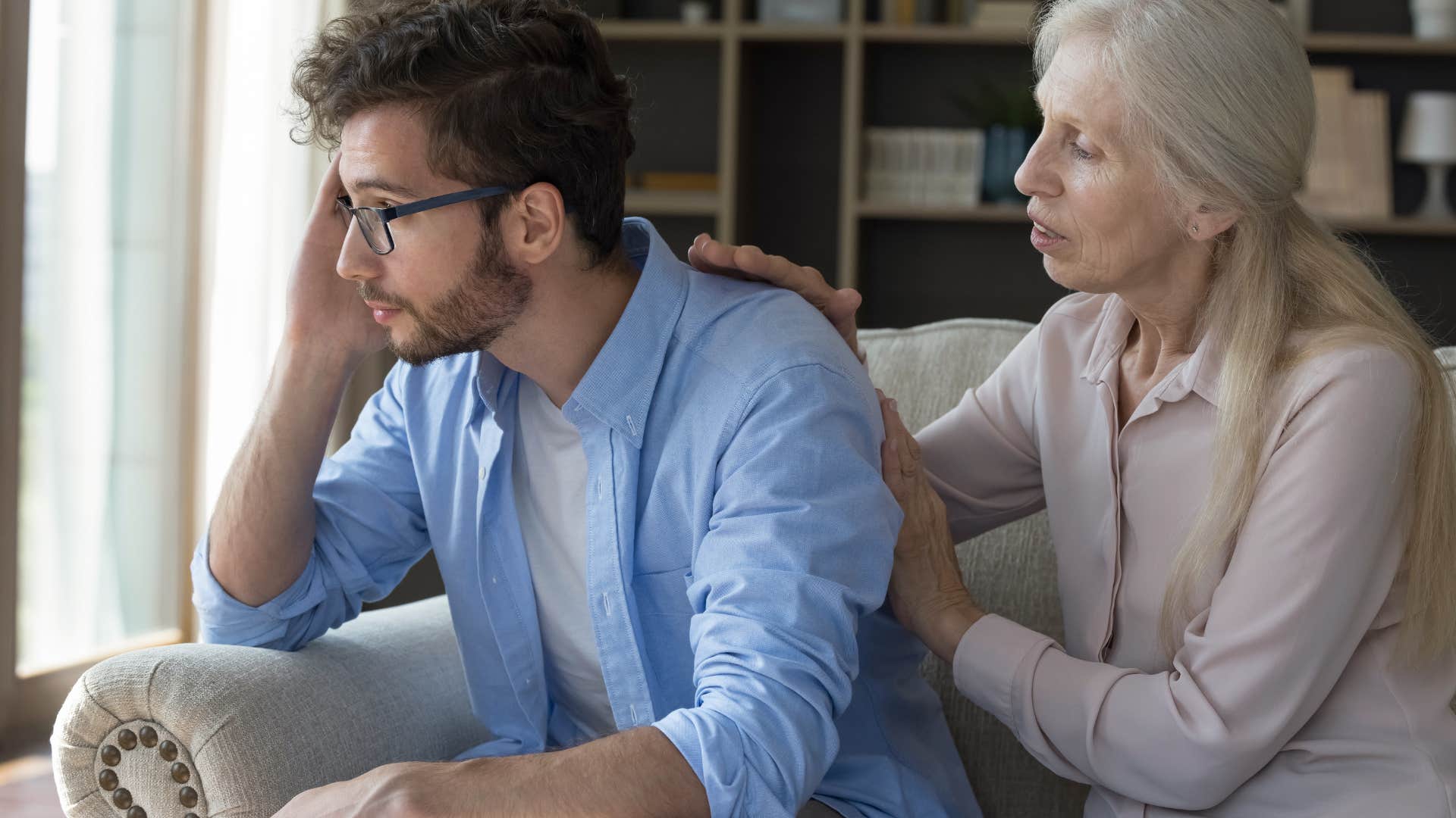 man saying you deserve it to his upset mother trying to comfort him