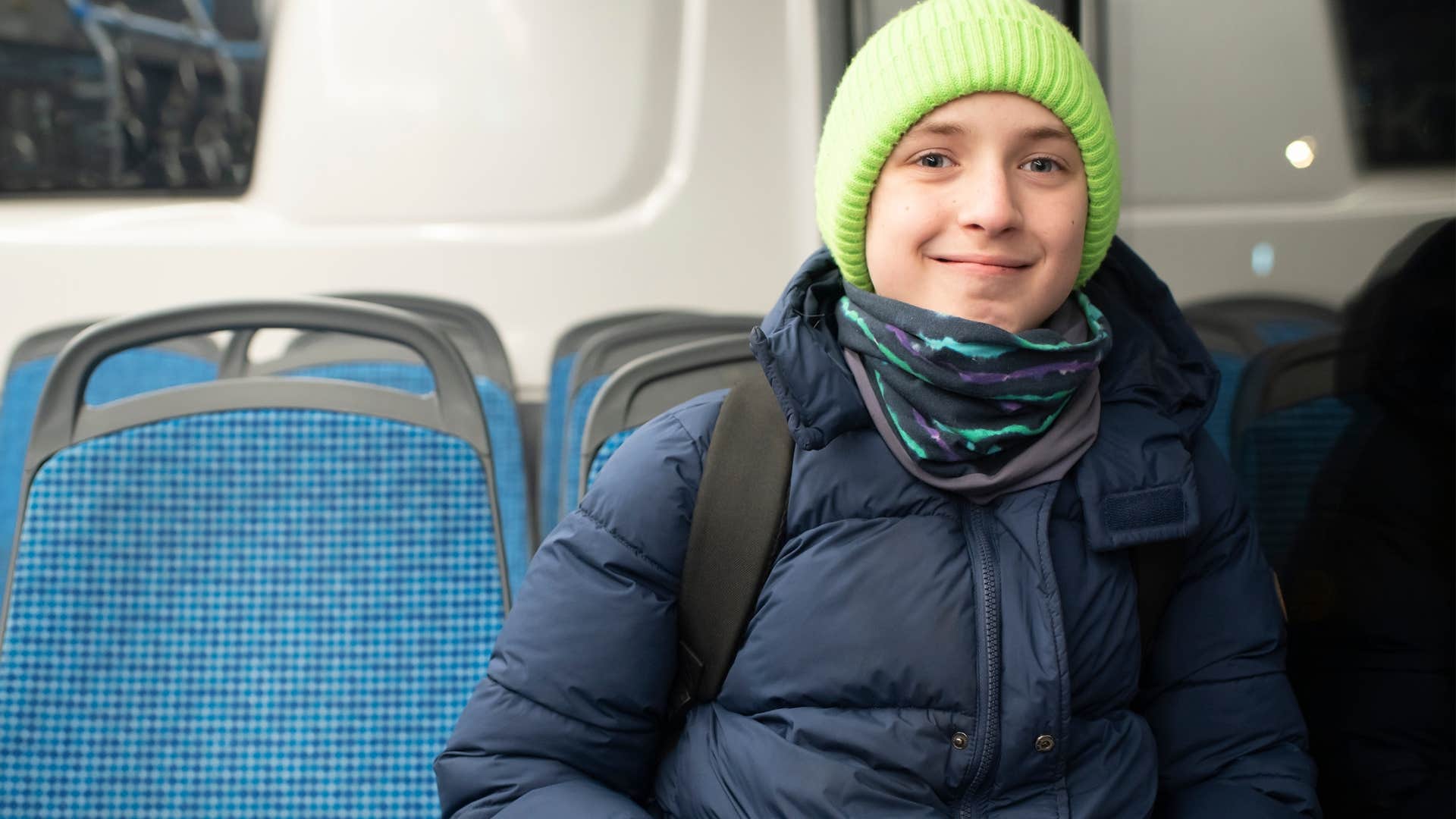 Little boy who travels on their own sitting on a bus.