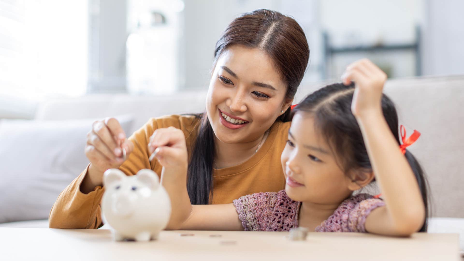 Little girl budgeting and saving money with her mother