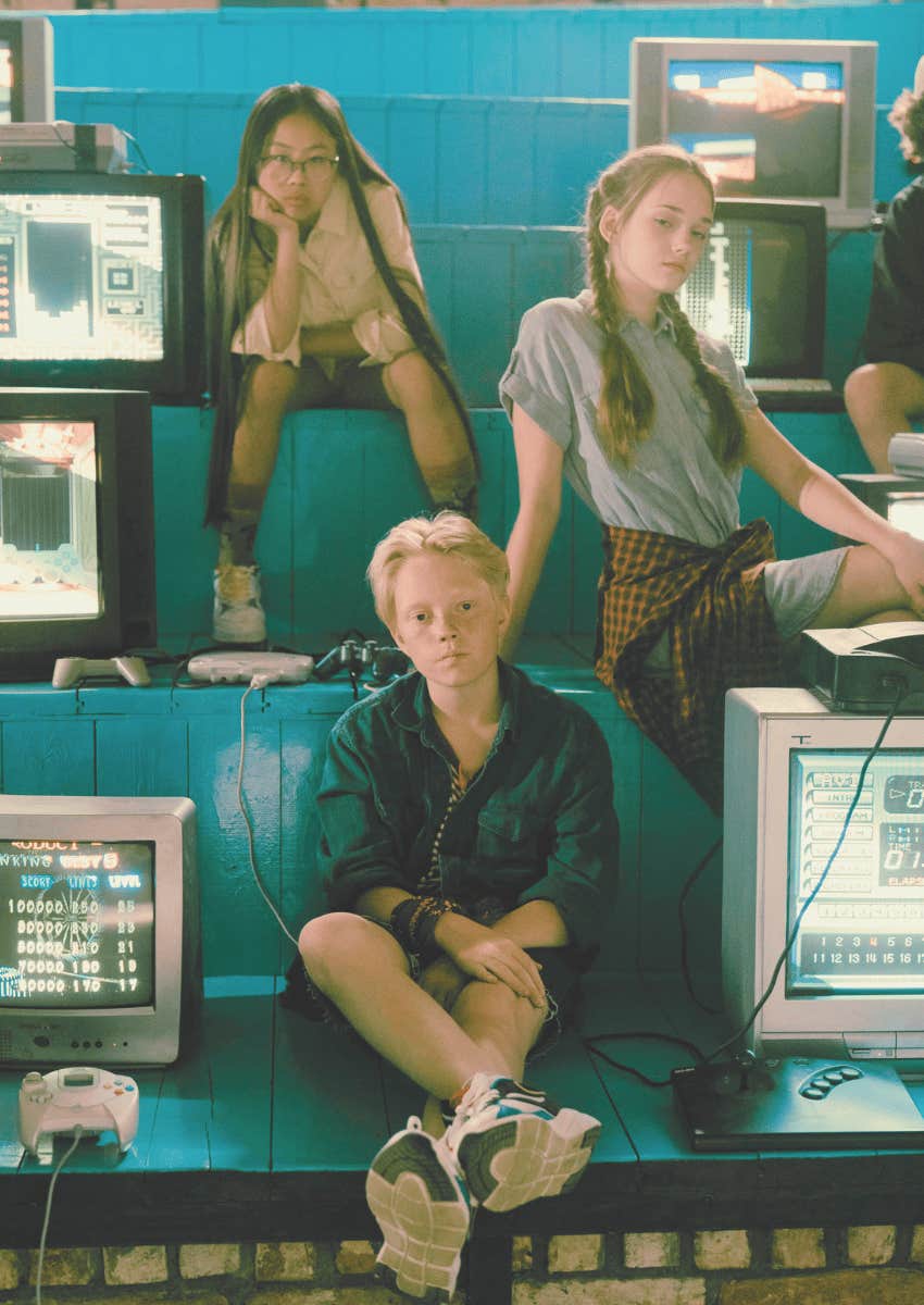 kids posing next to 1980s tv sets