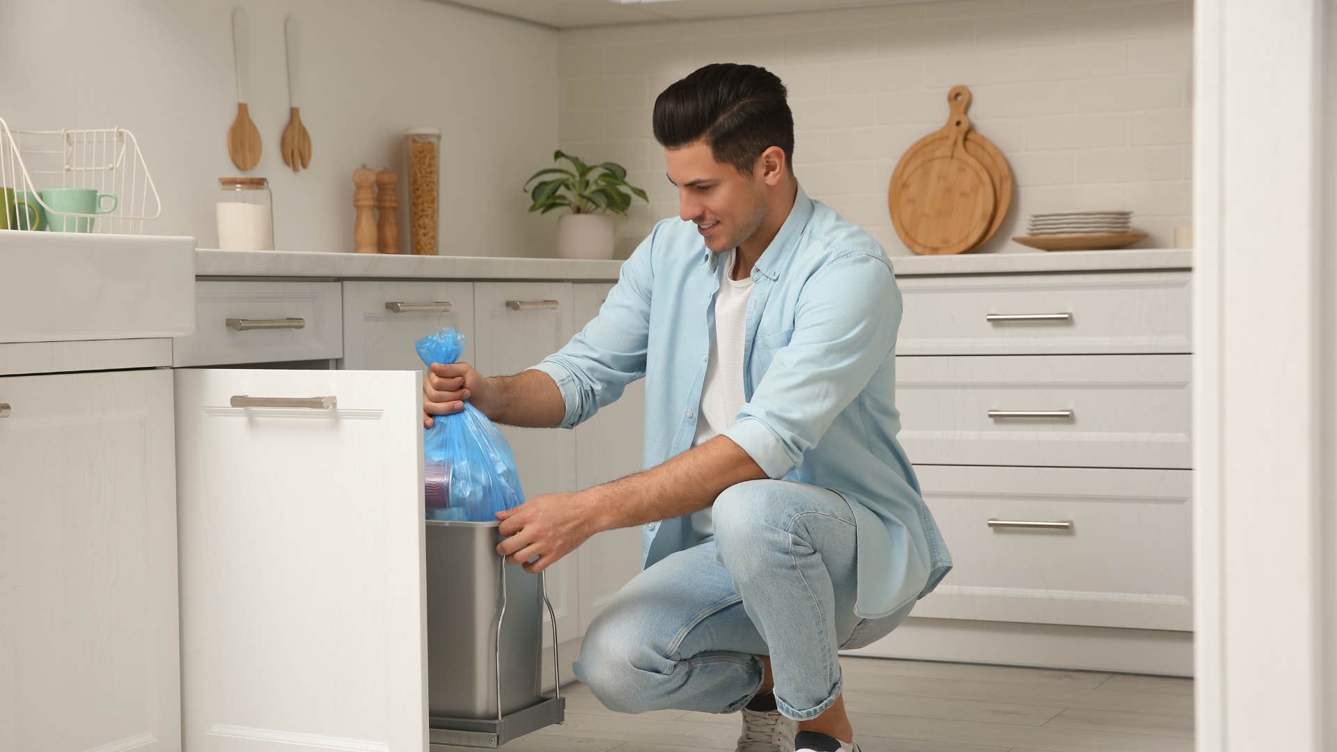man taking trash out of bin