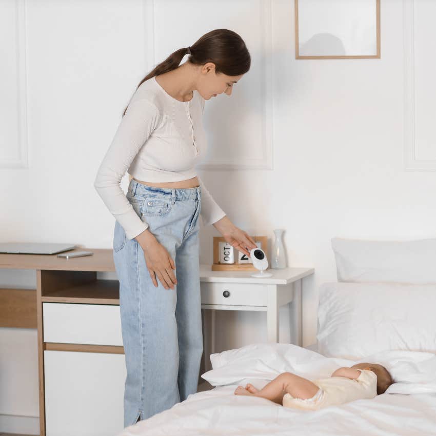 mom setting up camera to watch sleeping baby