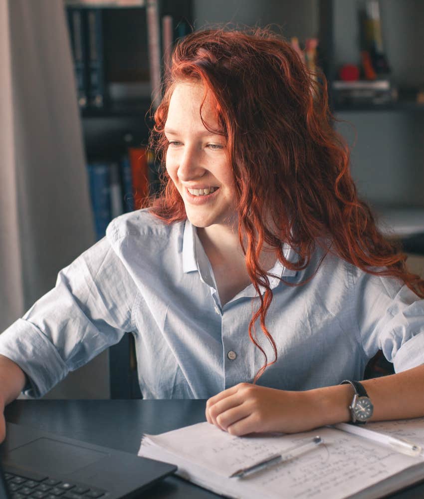 Happy young person at computer with papers showing preparation is life skill