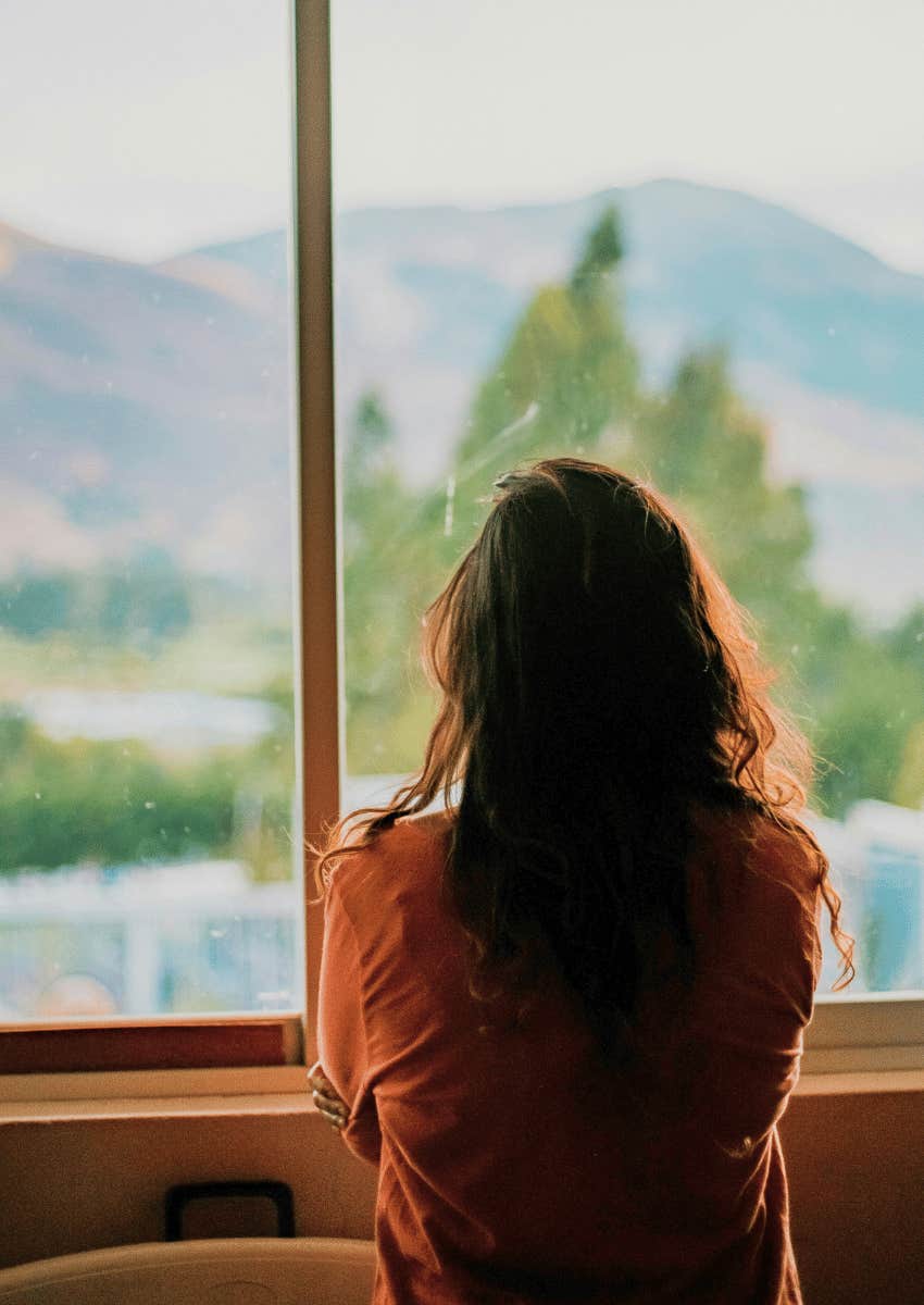 lonely woman looking out of window