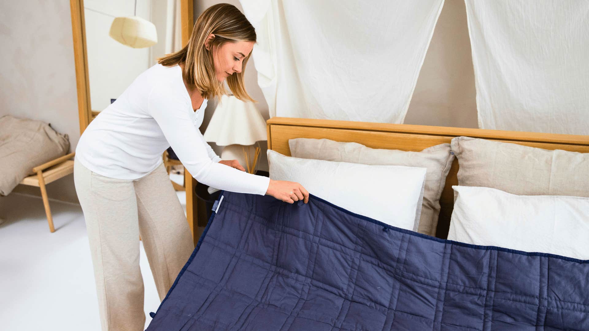 woman making bed to feel less overwhelmed