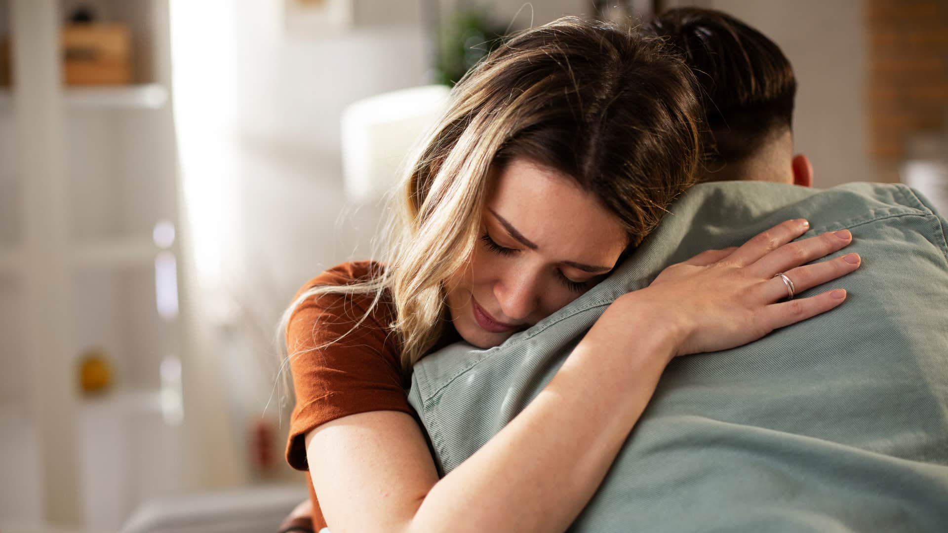 man softening hugging his upset partner