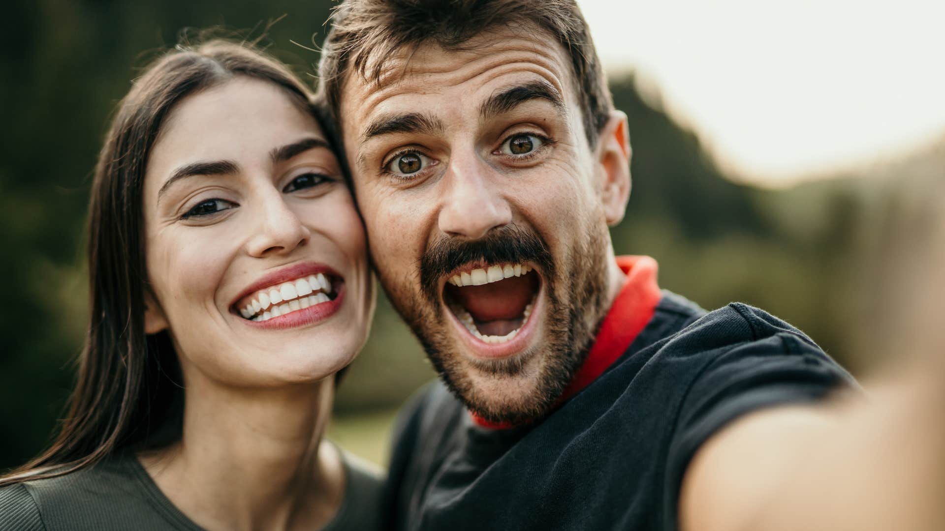 lighthearted and fun man taking silly selfie with woman