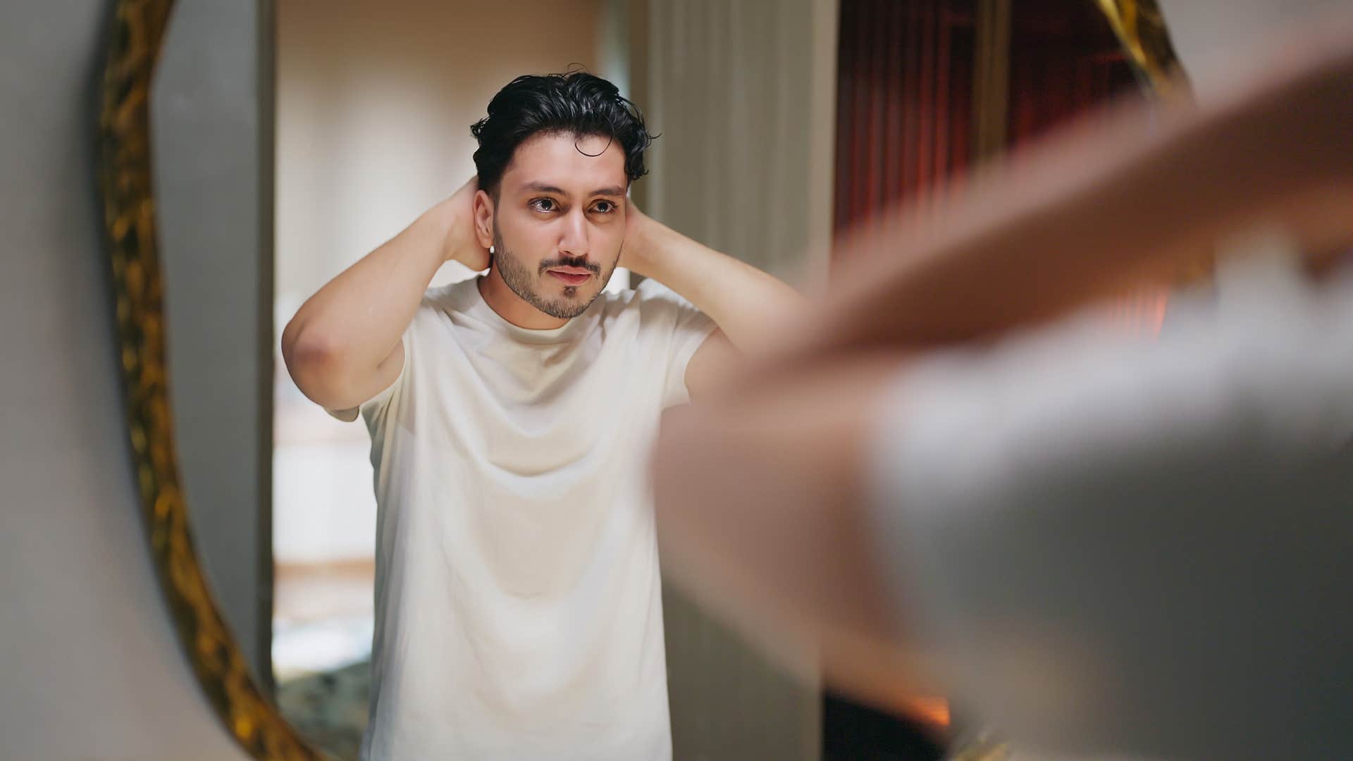 man looking in the mirror not feeling self-conscious