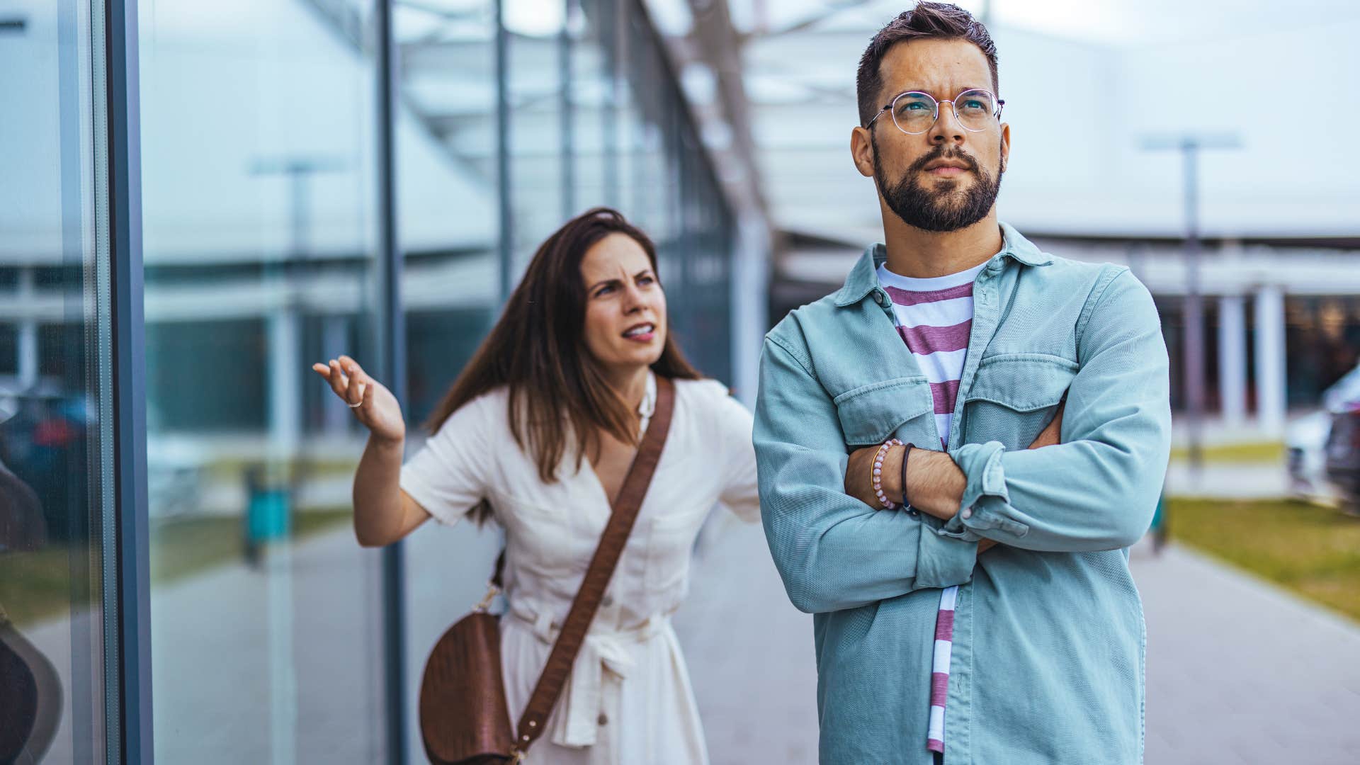 stressed man who gets defensive easily arguing with his wife in public