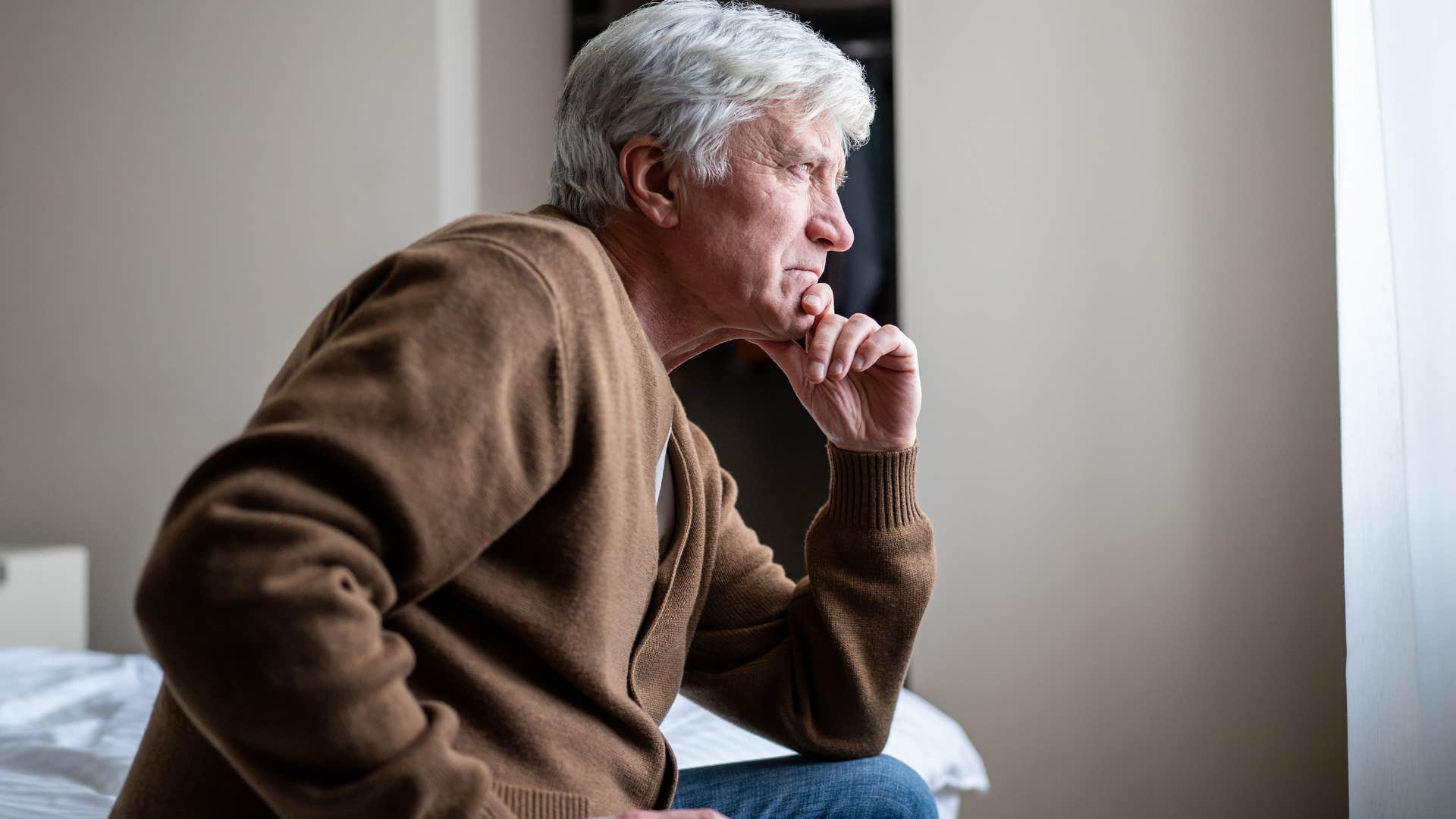 stressed man acting withdrawn sitting alone at home