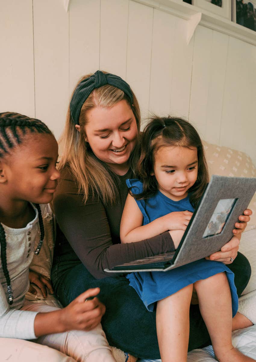 mother making her kids feel loved by showing them photo albums