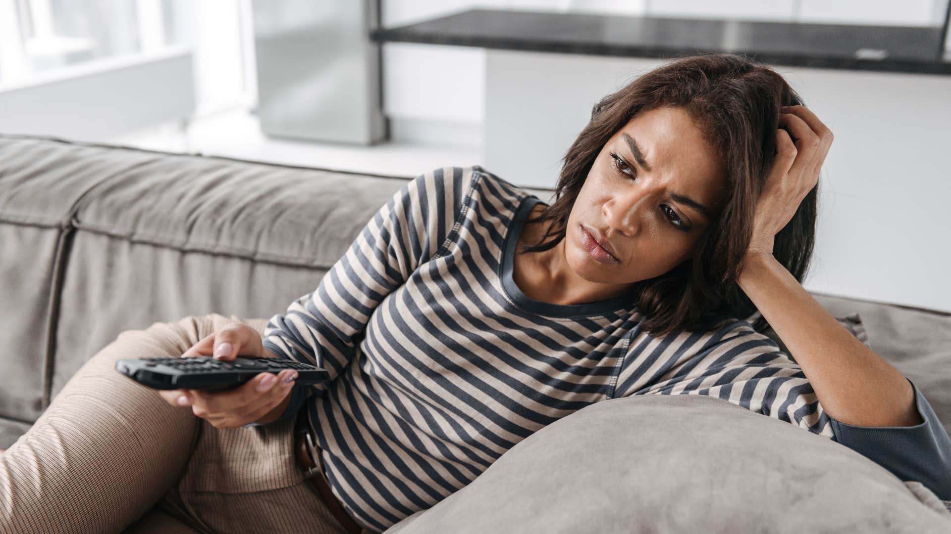 Bored person watching TV showing they might be obsessed