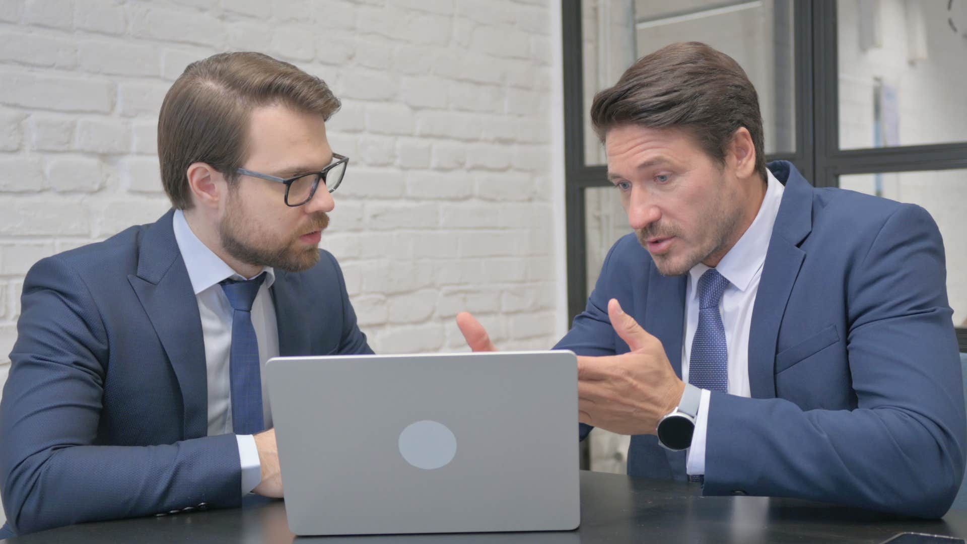 stubborn man who struggles to accept feedback arguing with a co-worker
