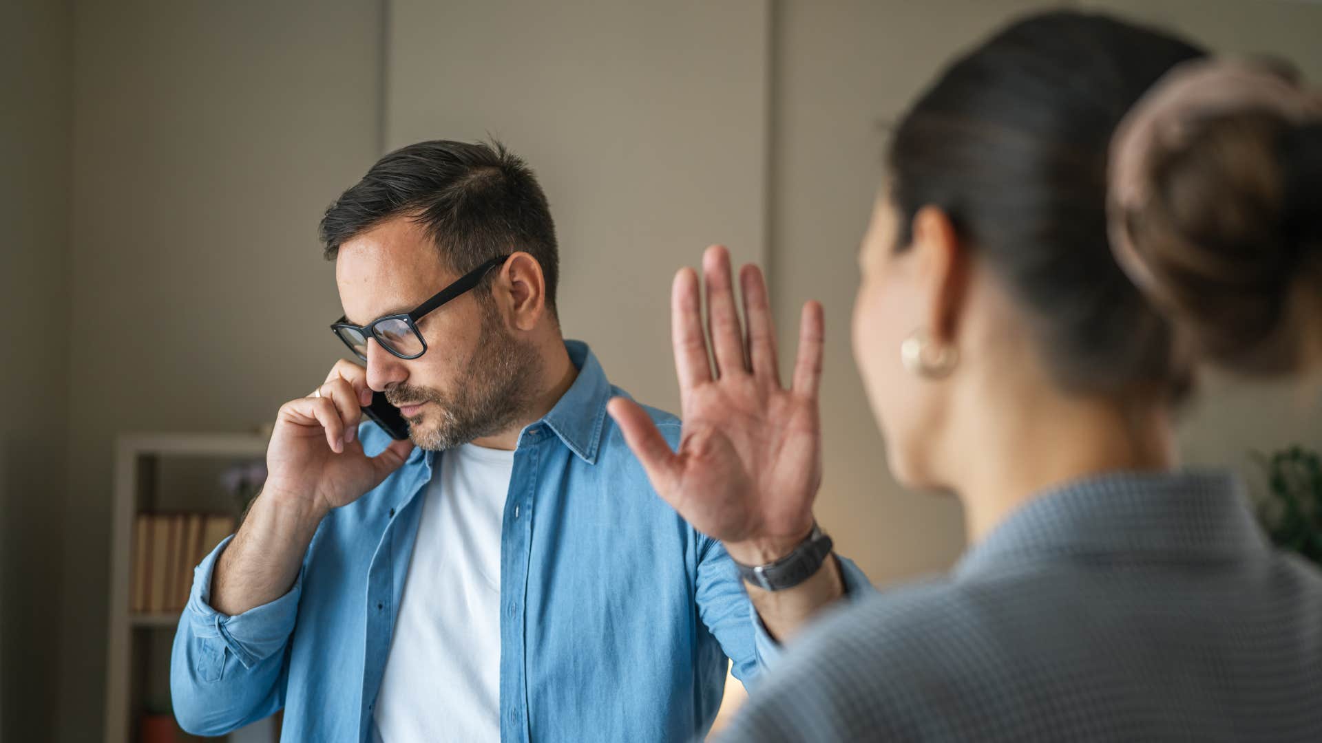 man acting busy as a distraction telling wife to go away