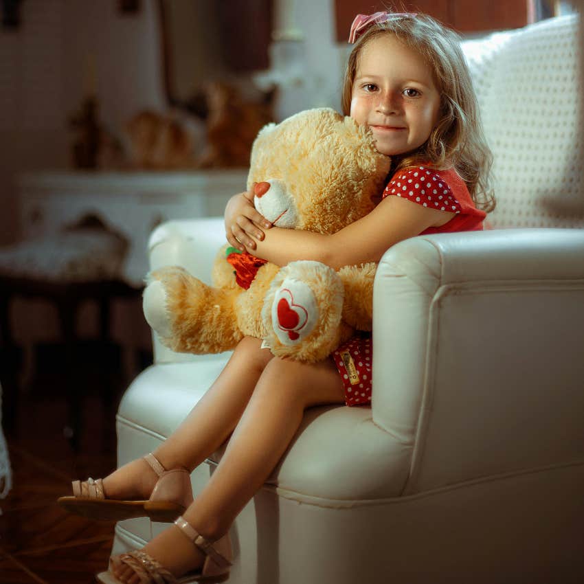 girl sitting in a chair that she keeps falling out of