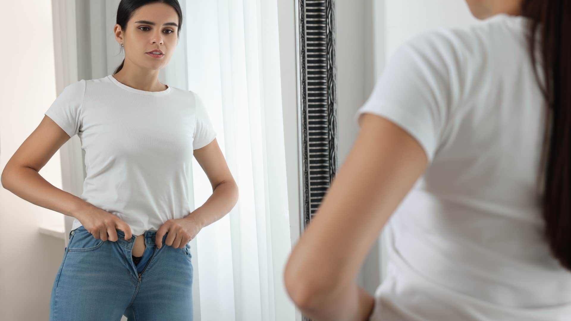 woman putting on flared jeans