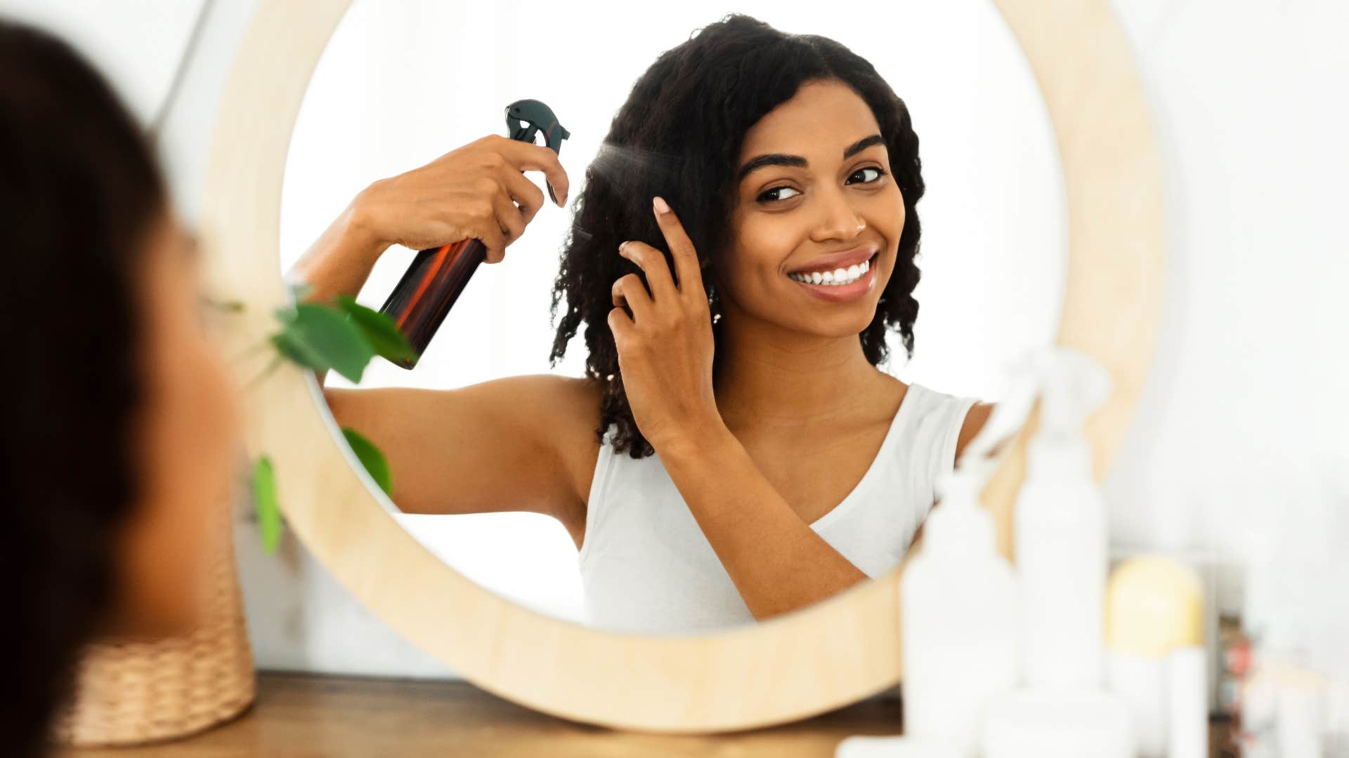 woman putting hairspray in her hair