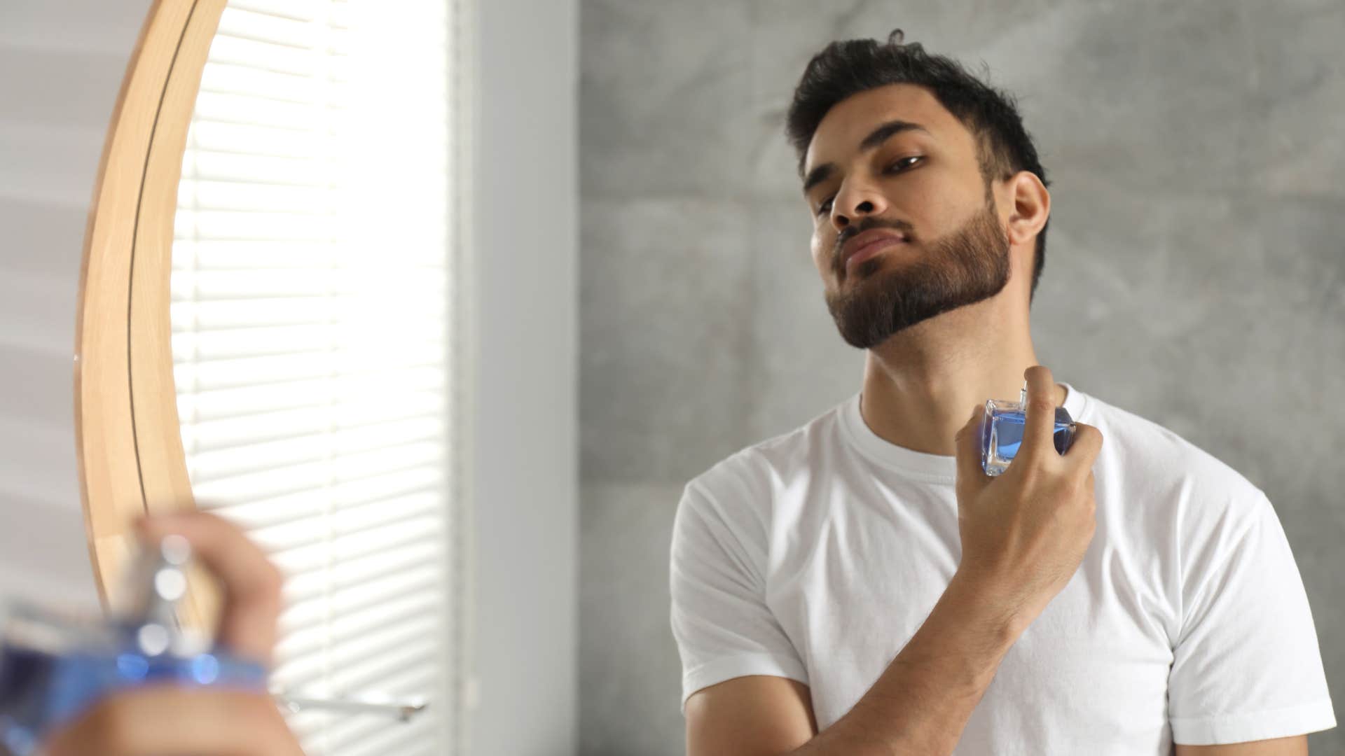 man spraying cologne with heavy musky scent