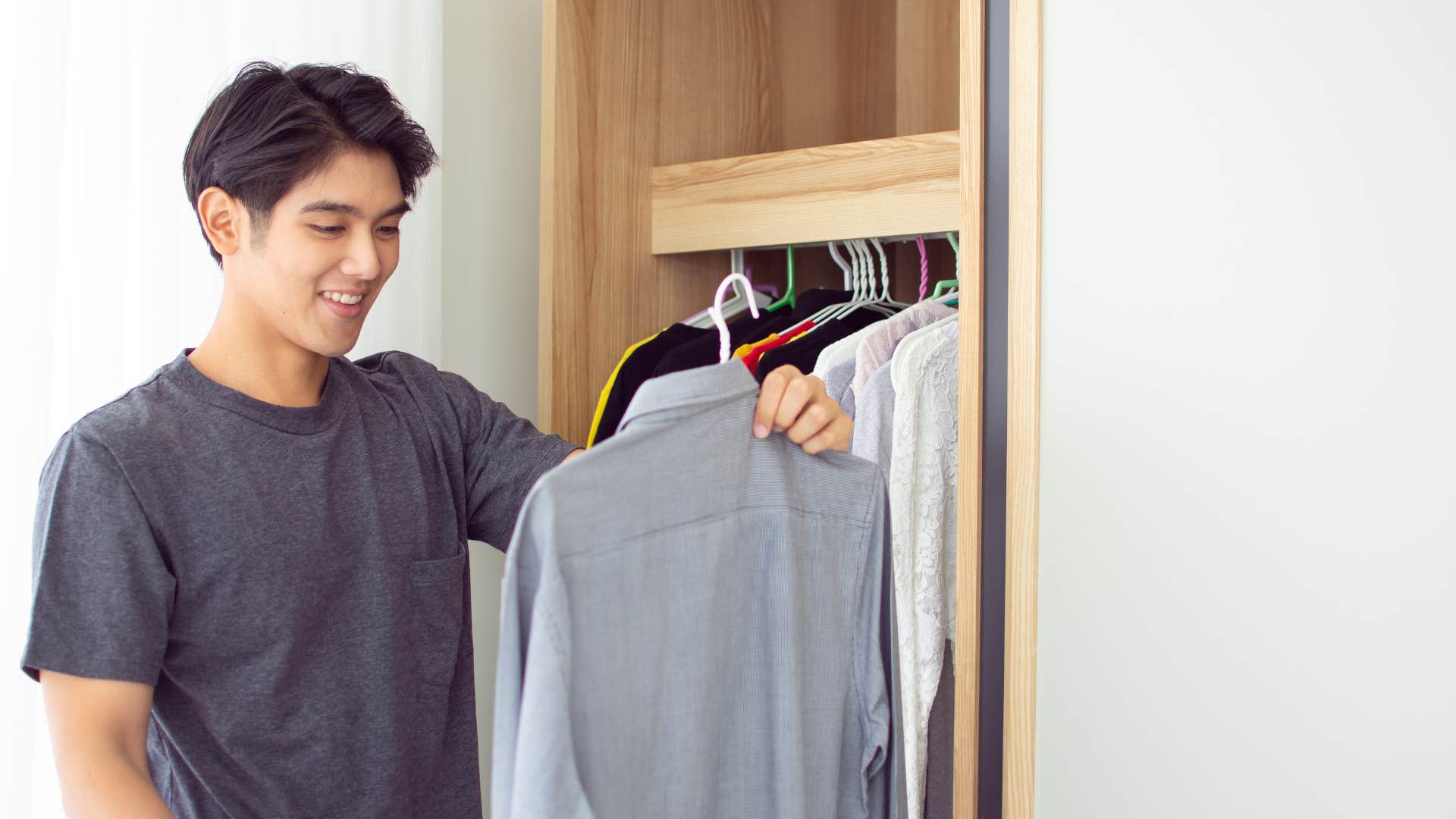 man picking out shirt made of polyester 