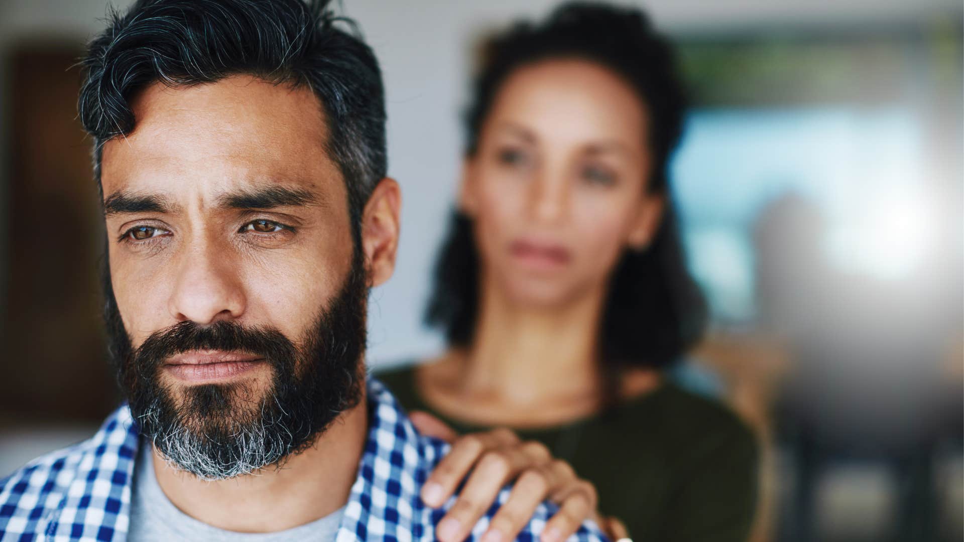 Kind person places gentle hand on partner's shoulder showing breakup