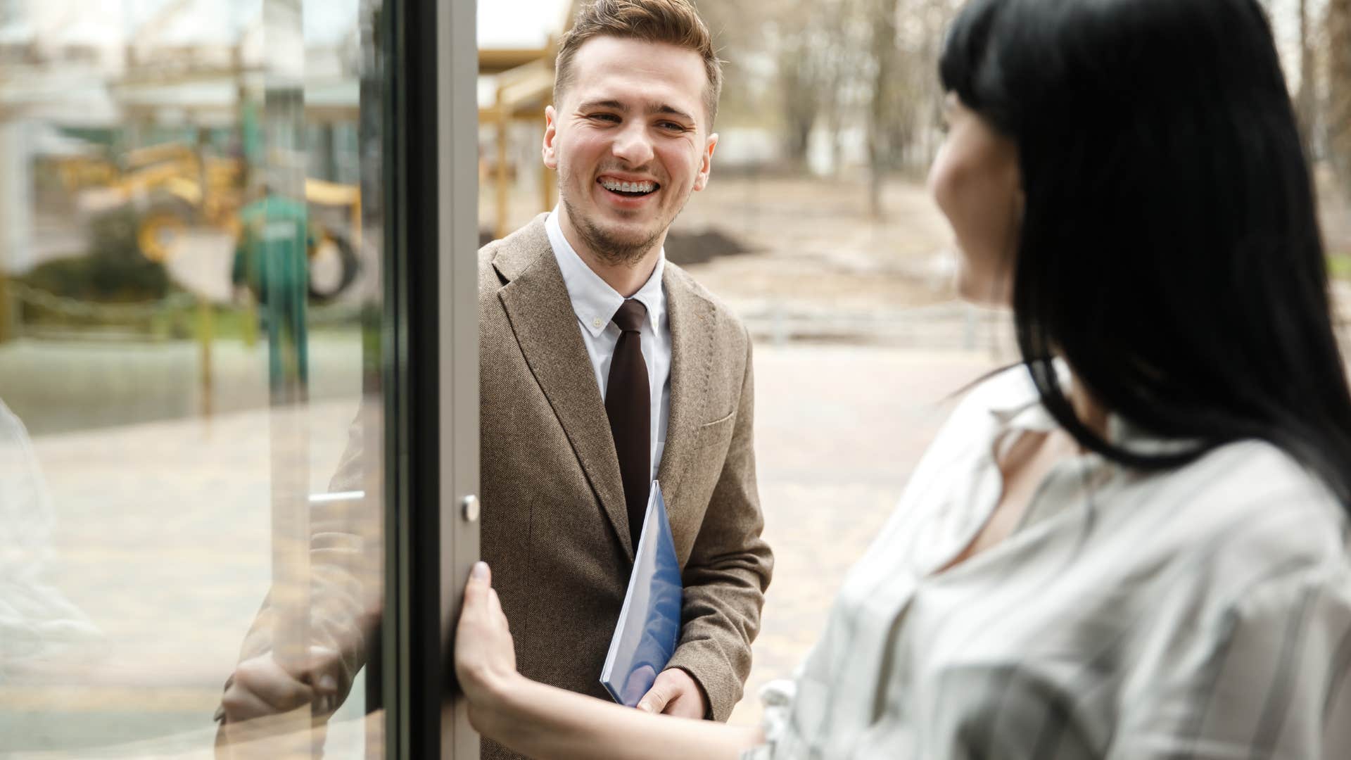 Man holds door showing chivalrous gesture