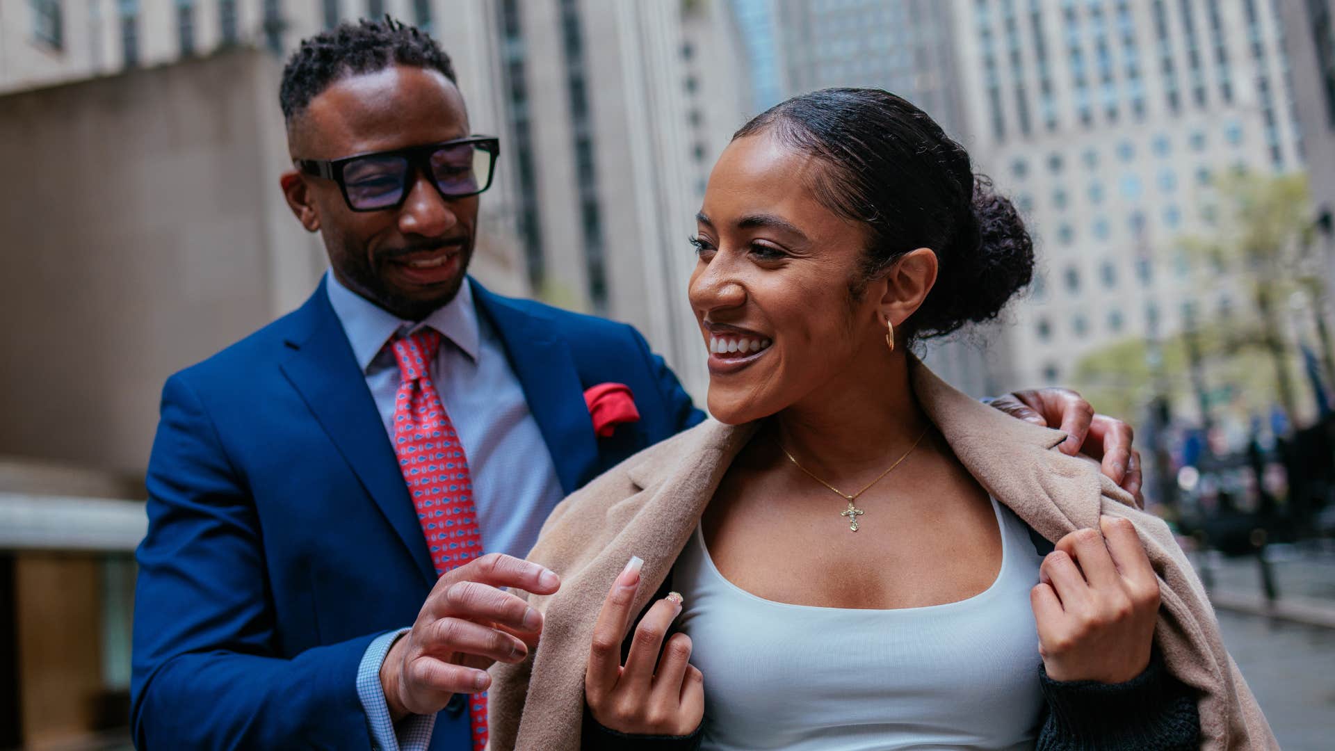 Chivalrous man helps woman with coat to stay warm