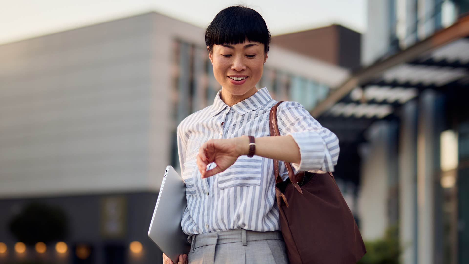 punctual woman looking at watch to arrive on time