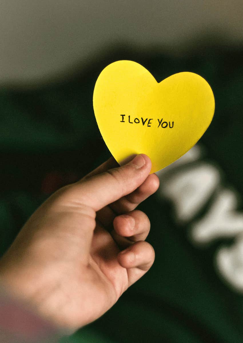 child holding note with message from parent feeling loved