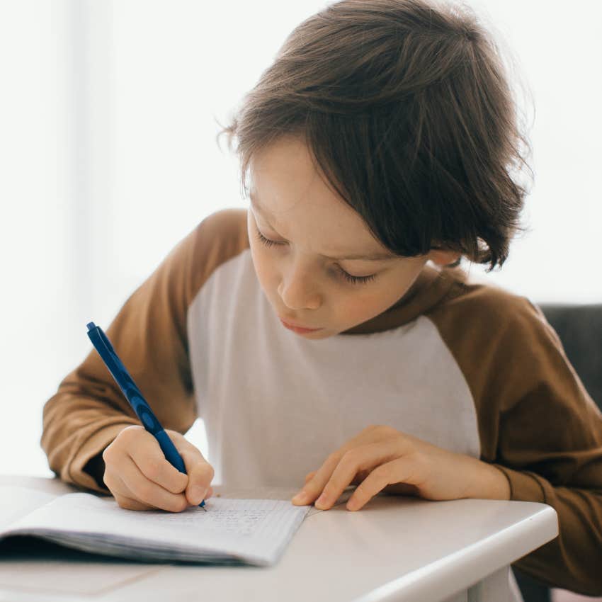 Little boy who is independent at his core doing homework at home.