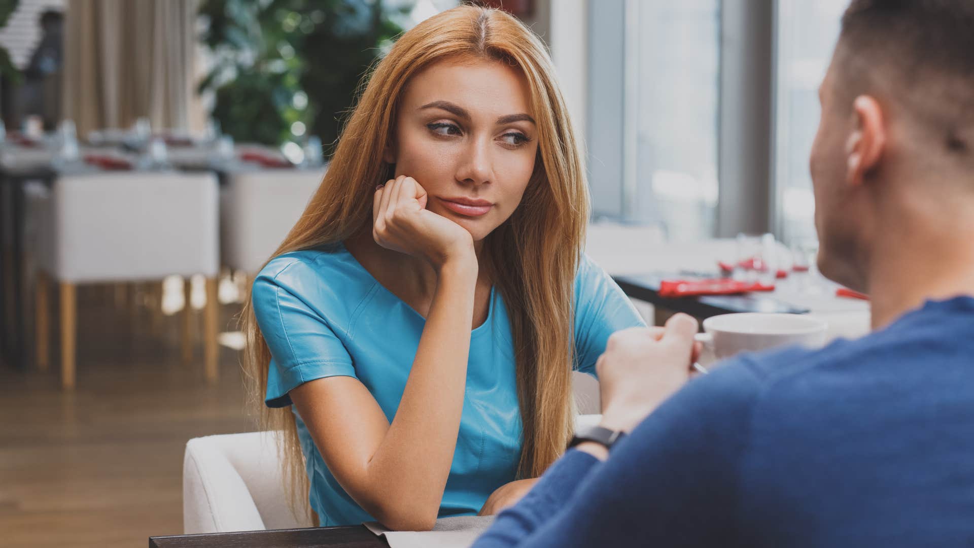 woman looking distracted in talk with man saying i don't really have time for this