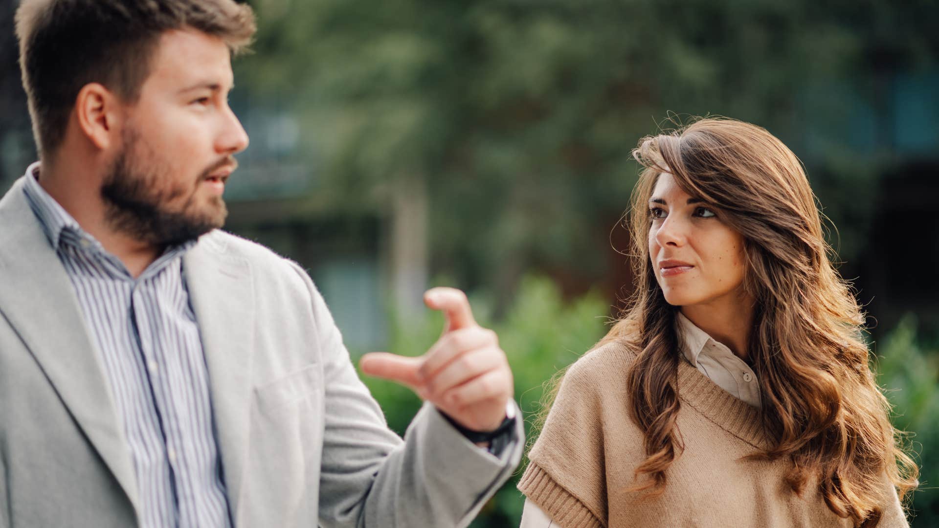 man talking to woman who is saying wait what not listening