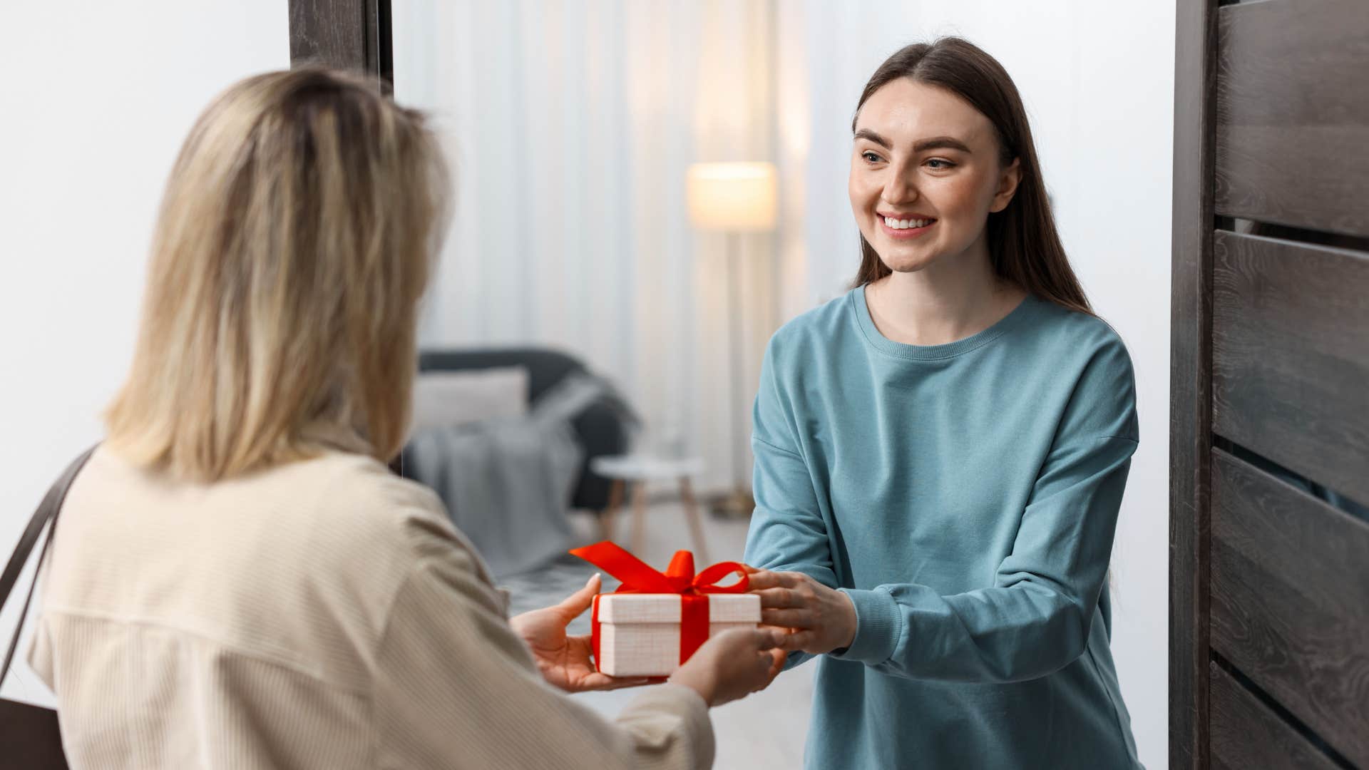 woman who hates opening gifts in front of others giving a present to someone