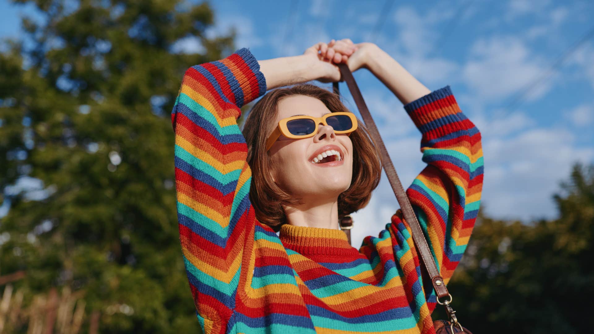 woman smiling happily outside in striped shirt