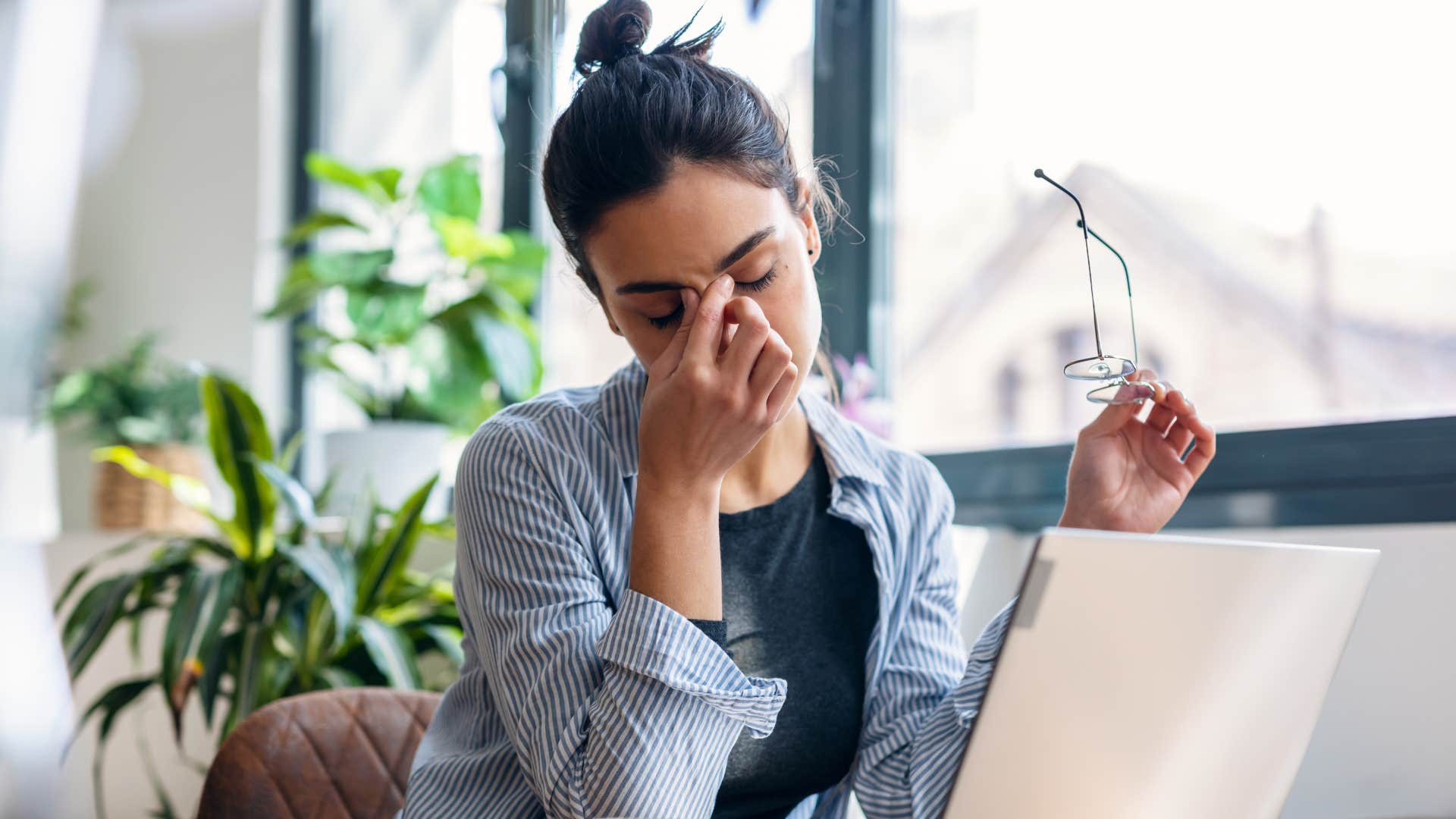 woman anxious as she takes a break from work to rub face