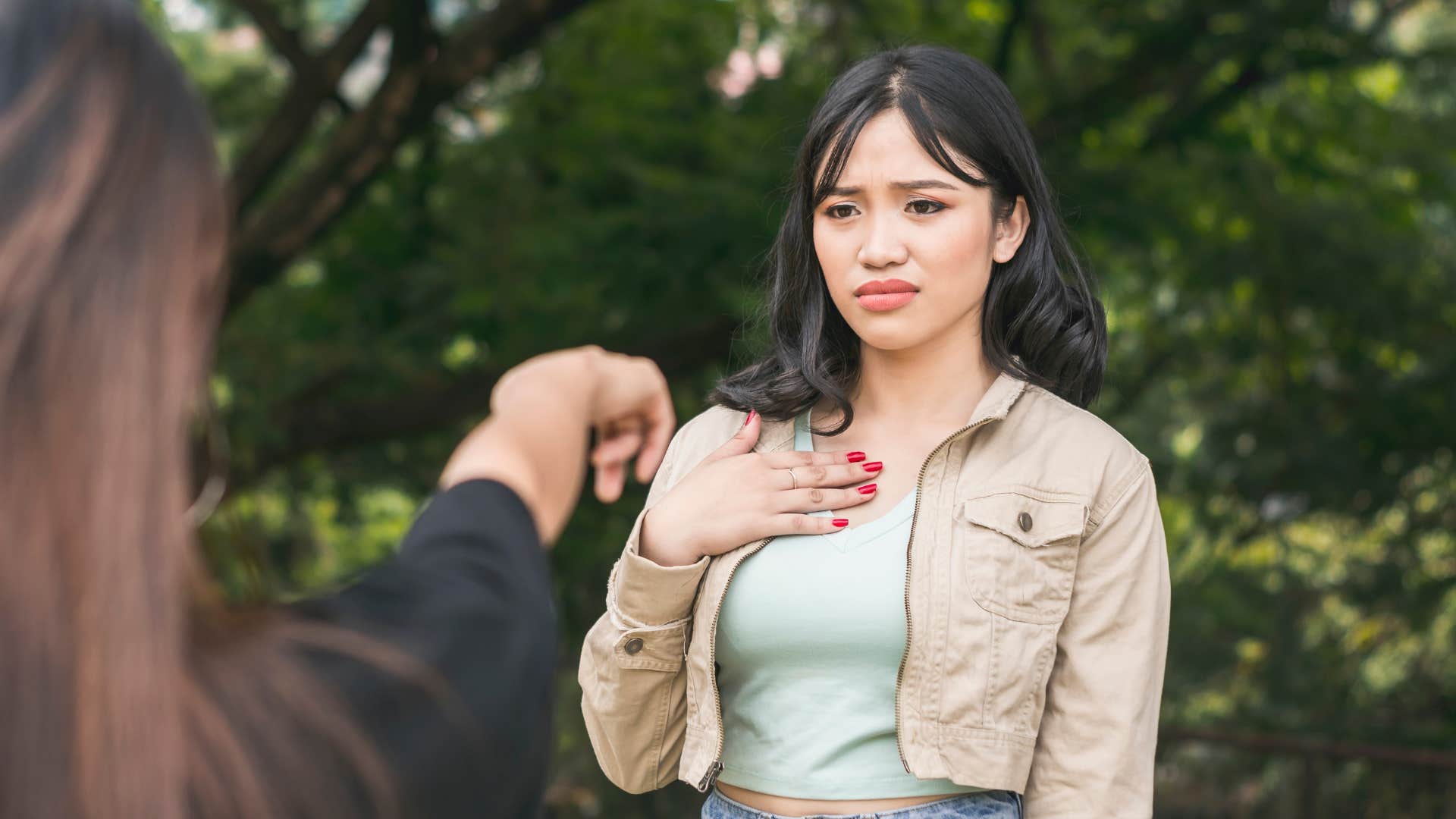 Disbelieving person touches chest showing struggle with criticism