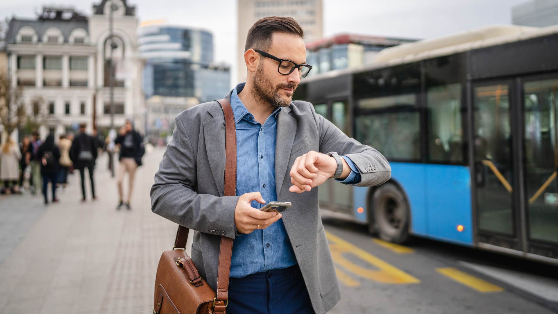 man in gray jacket checking watch impatiently