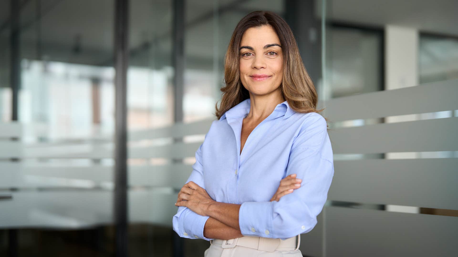 woman in blue shirt being assertive as she crosses arms