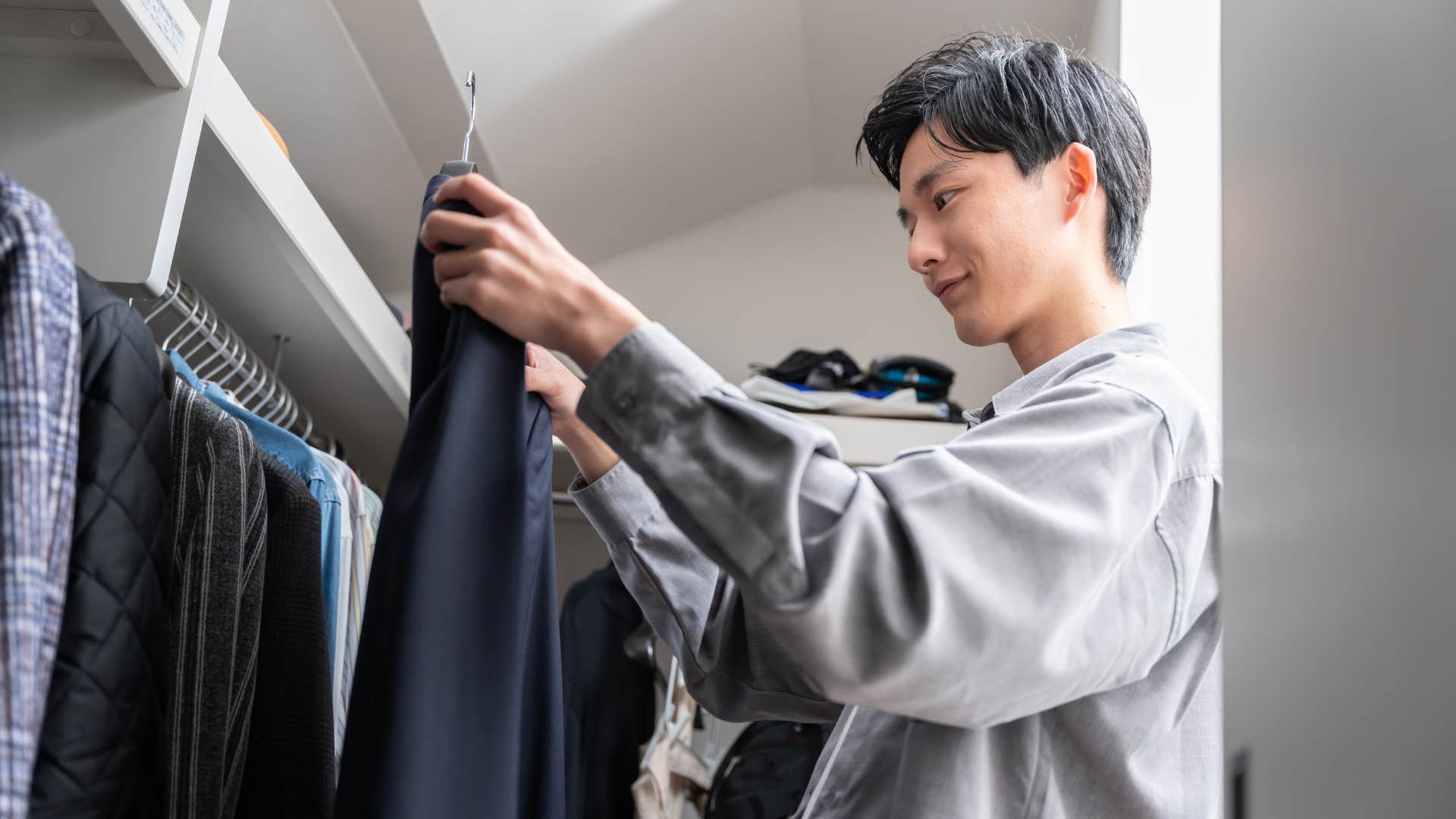 focused man being intentional about his outfit in his closet