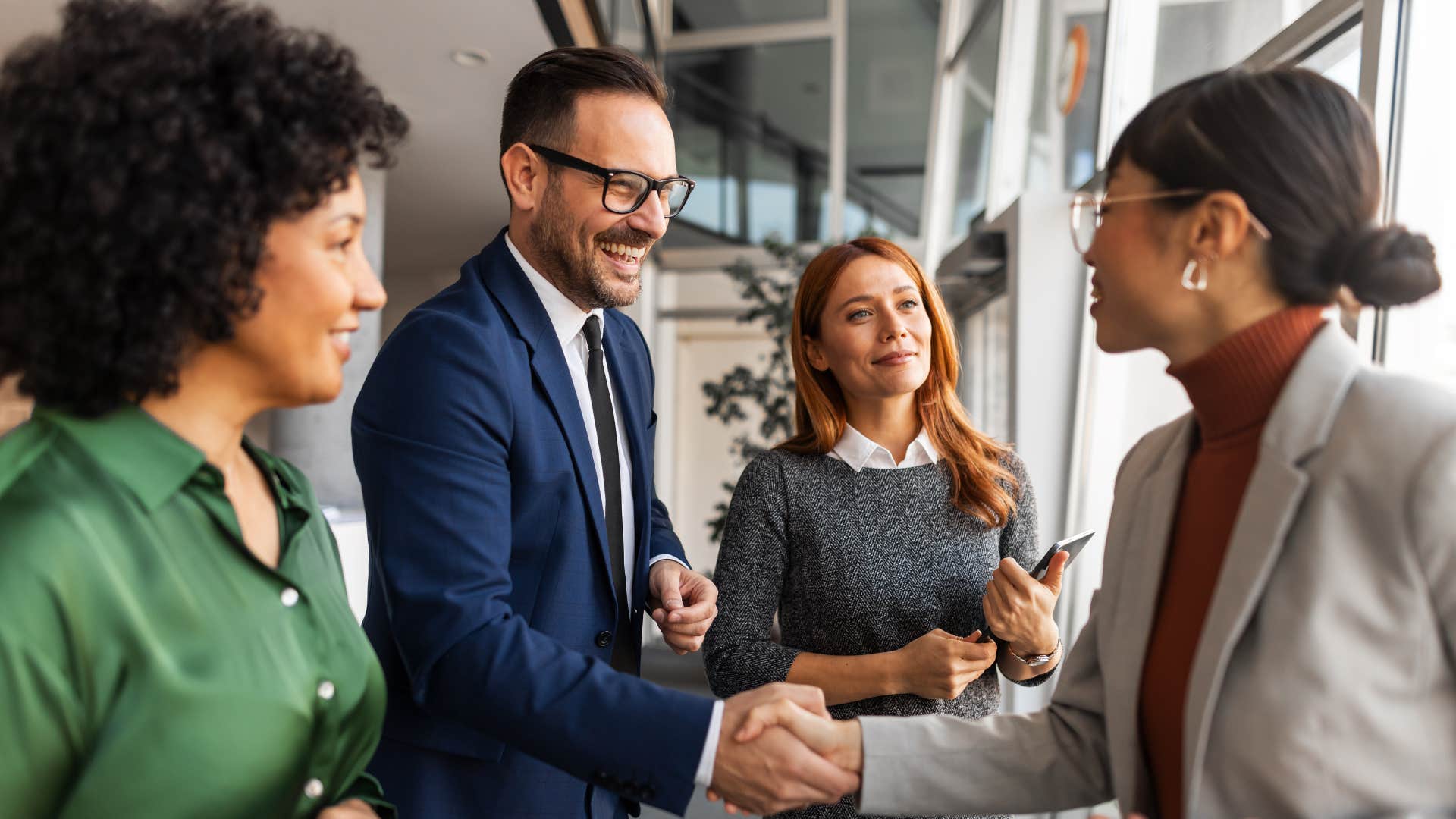 man who knows how to read a room shaking hands with colleagues