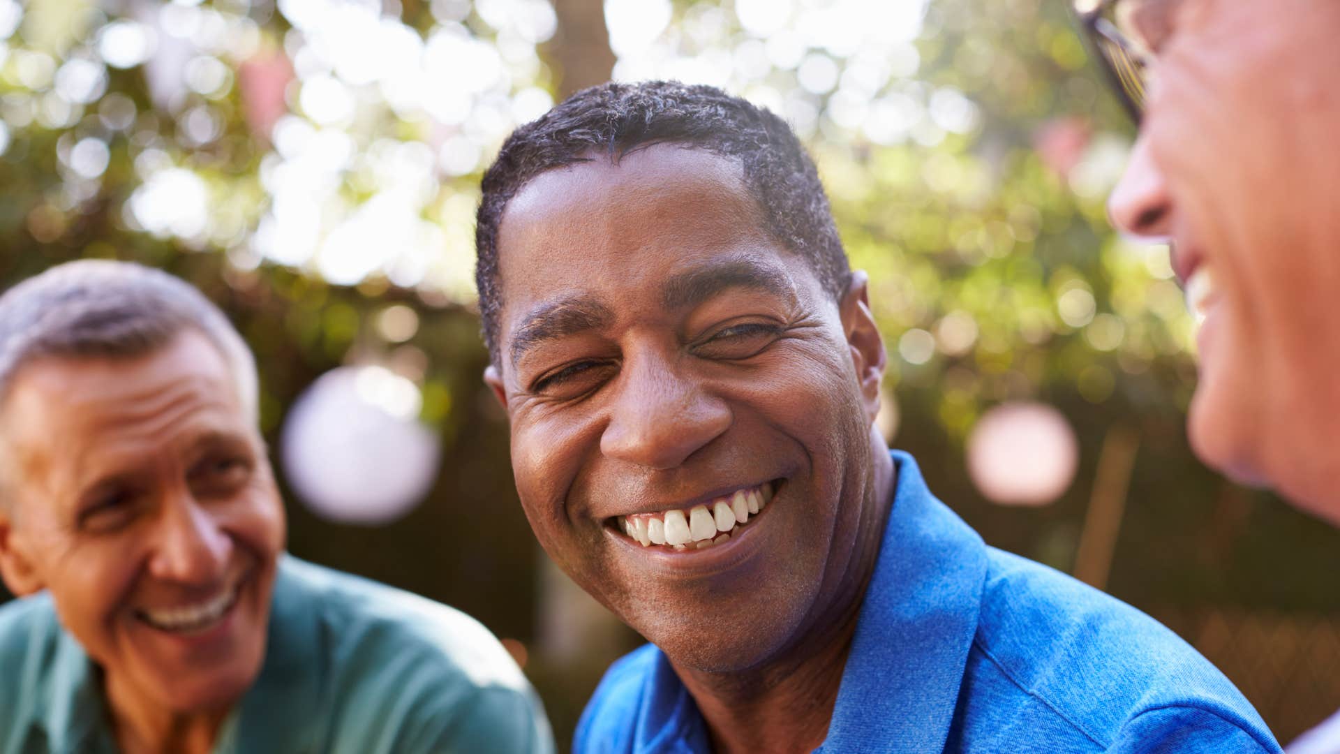 socially aware man smiling around his friends