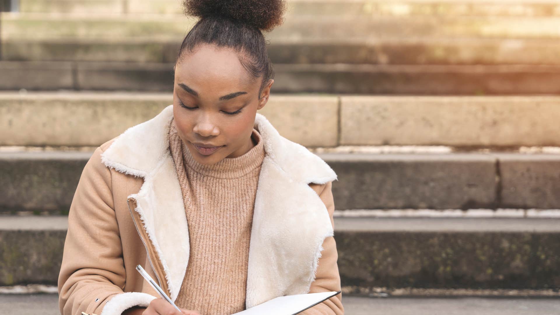 naturally introspective woman journaling outside