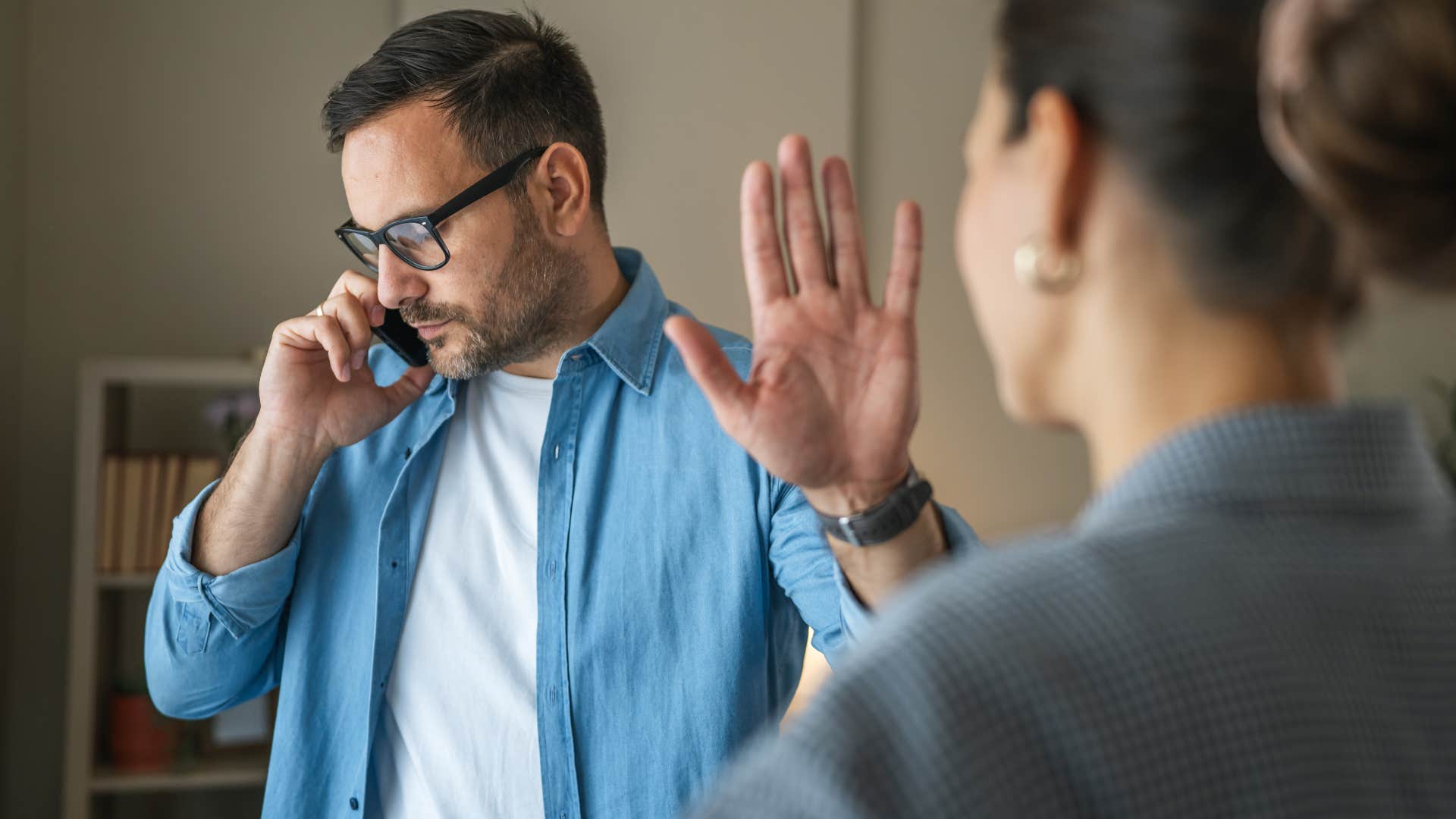 man dealing with interruptions while talking on the phone