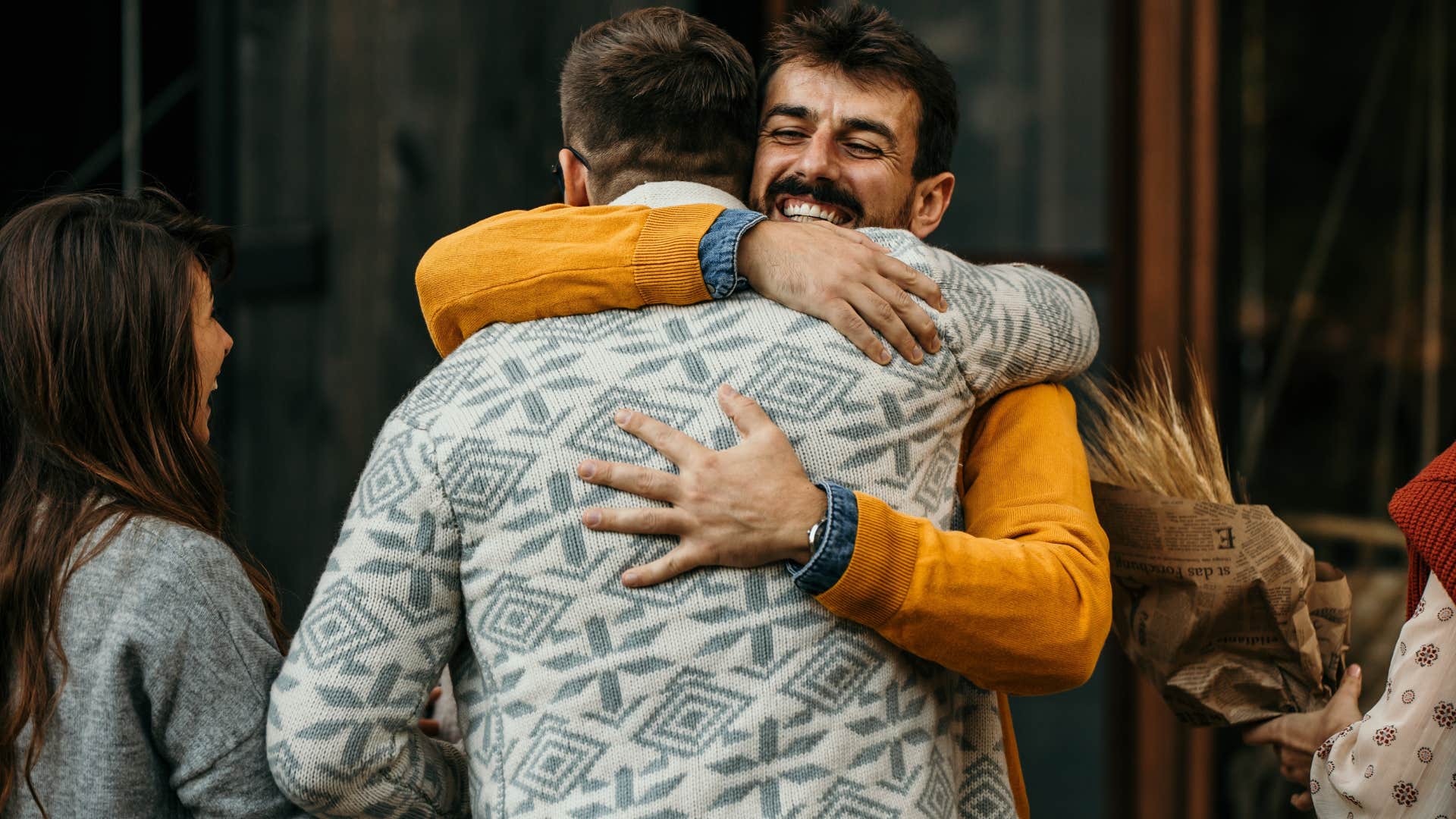 man circling back to gratitude by hugging his friend