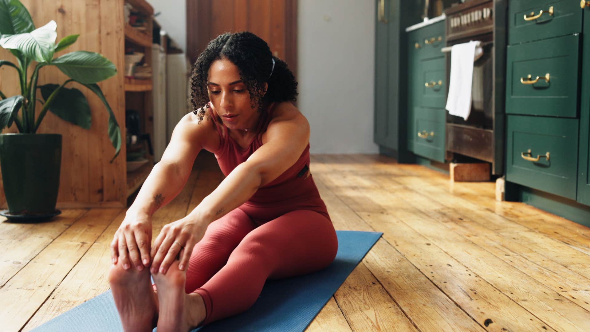 woman aspires to be healthier while doing yoga on mat